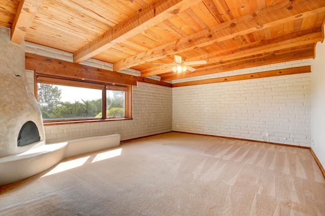 interior space with beam ceiling, carpet, ceiling fan, brick wall, and wooden ceiling