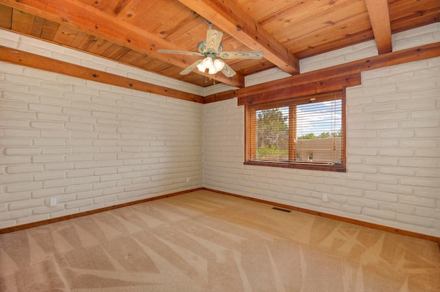 carpeted spare room featuring wood ceiling, beam ceiling, ceiling fan, and brick wall