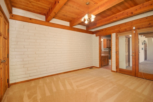 carpeted spare room featuring a notable chandelier, wooden ceiling, beam ceiling, and brick wall