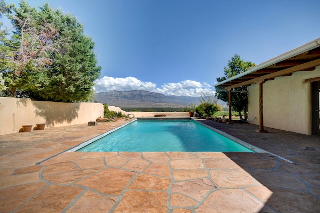 view of swimming pool with a patio and a mountain view