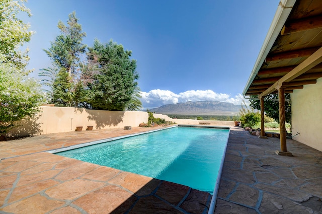 view of swimming pool featuring a mountain view and a patio area