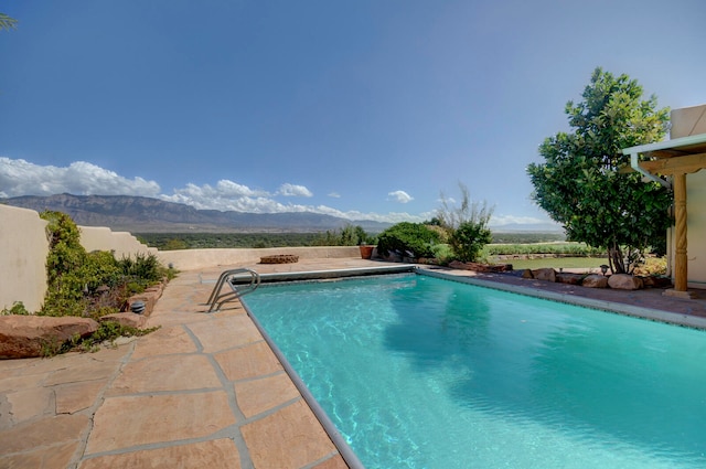 view of pool with a mountain view and a patio area