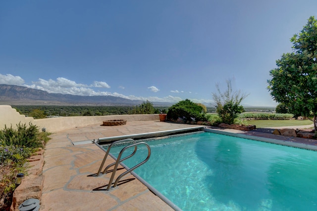 view of pool with a patio and a mountain view