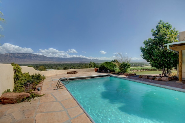 view of swimming pool featuring a mountain view and a patio area