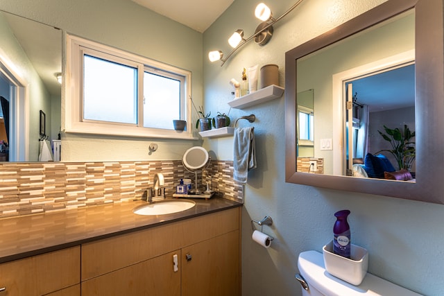 bathroom featuring decorative backsplash, vanity, and toilet