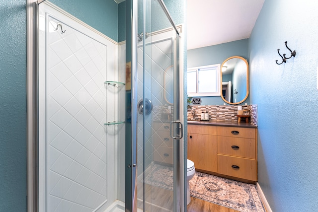 bathroom with walk in shower, hardwood / wood-style floors, toilet, and sink