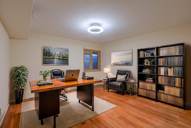 office space featuring light hardwood / wood-style flooring and a textured ceiling