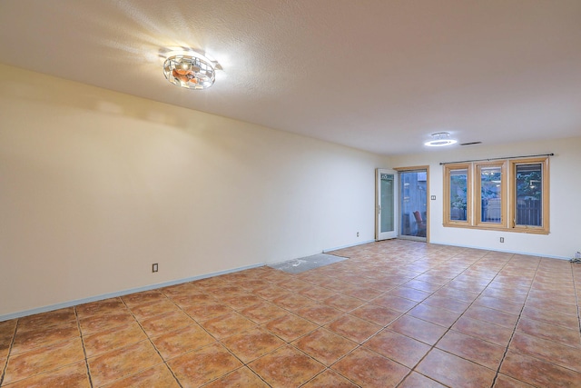 tiled spare room with a textured ceiling