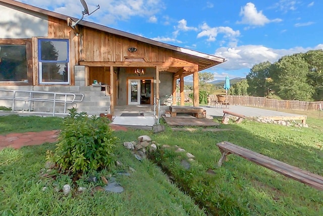 back of property featuring a patio area and a yard