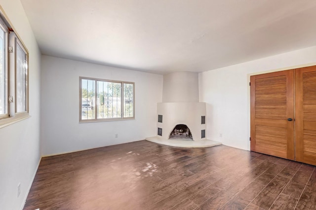 unfurnished living room featuring a large fireplace and dark wood-type flooring