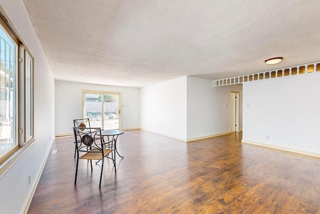 dining room featuring a textured ceiling and dark wood-type flooring