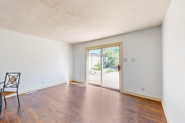 unfurnished room featuring a textured ceiling and dark wood-type flooring