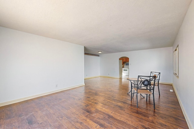 dining space with a textured ceiling and dark wood-type flooring