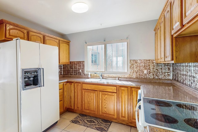 kitchen with sink, backsplash, light tile patterned floors, and white appliances