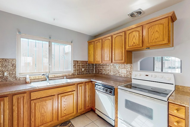 kitchen with decorative backsplash, white appliances, sink, and light tile patterned floors