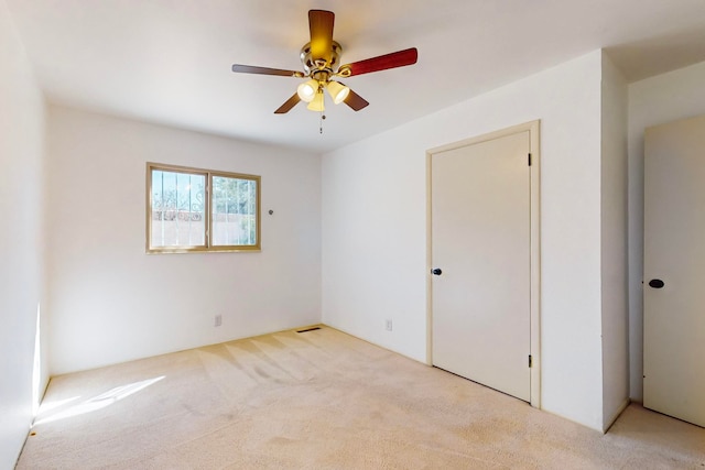 empty room with ceiling fan and light colored carpet