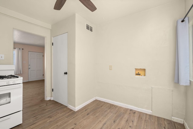 interior space with ceiling fan, light wood-type flooring, and white gas range oven