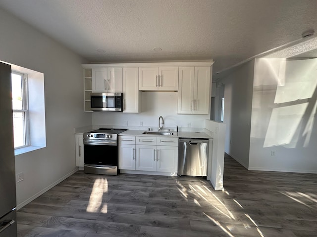 kitchen featuring white cabinets, appliances with stainless steel finishes, dark hardwood / wood-style floors, and sink