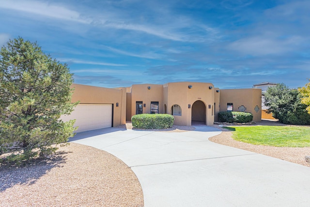 1220 Mesa Ridge Dr SW, Los Lunas, NM 87031 - pueblo revival-style home featuring stucco siding, concrete driveway, and a garage