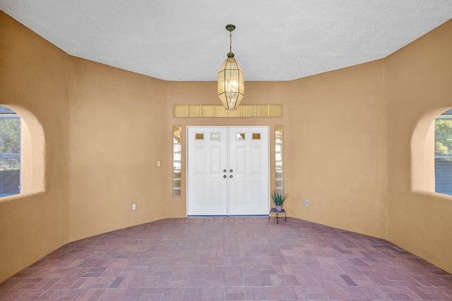 foyer with a chandelier and a textured ceiling