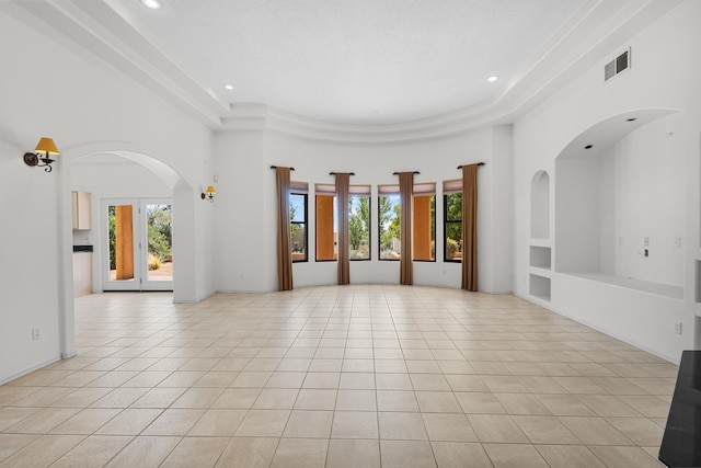 spare room featuring light tile patterned flooring, built in features, a high ceiling, and a textured ceiling