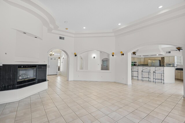 1220 Mesa Ridge Dr SW, Los Lunas, NM 87031 - unfurnished living room featuring light tile patterned floors, a raised ceiling, a ceiling fan, recessed lighting, and arched walkways