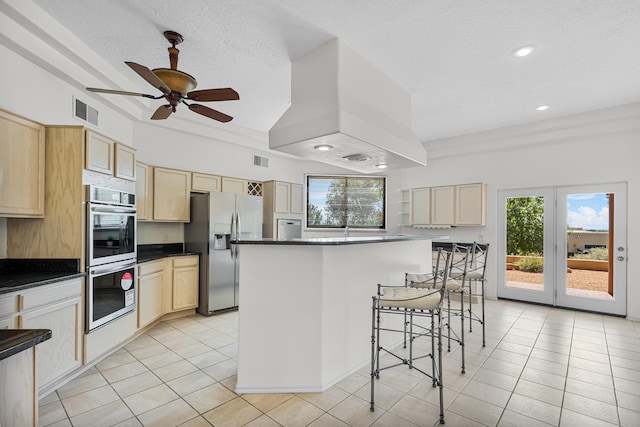 kitchen with a kitchen island, ceiling fan, stainless steel appliances, and a wealth of natural light