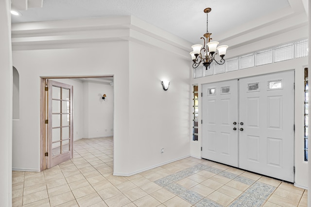 tiled foyer with a healthy amount of sunlight and a chandelier