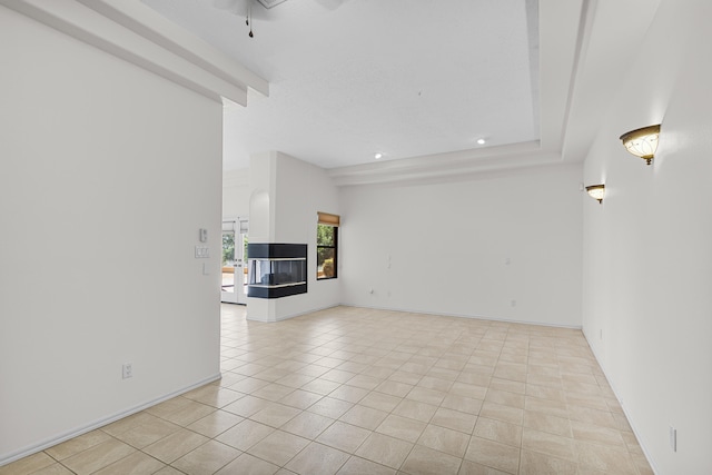 unfurnished living room featuring a multi sided fireplace, light tile patterned flooring, and beamed ceiling