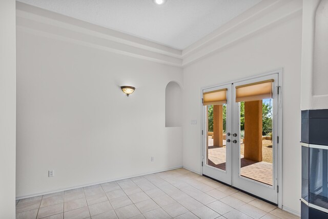 1220 Mesa Ridge Dr SW, Los Lunas, NM 87031 - spare room with french doors, arched walkways, and tile patterned flooring
