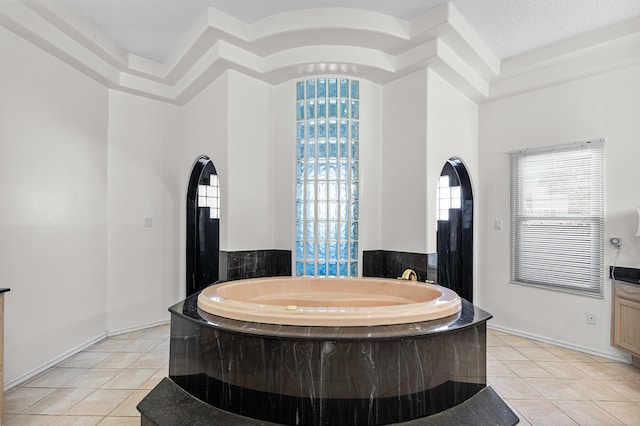 bathroom featuring a bath, a textured ceiling, and tile patterned flooring