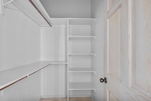 walk in closet with light tile patterned flooring