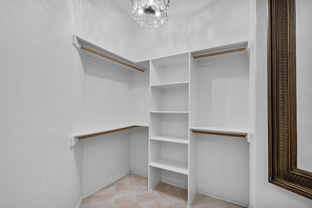 spacious closet with an inviting chandelier