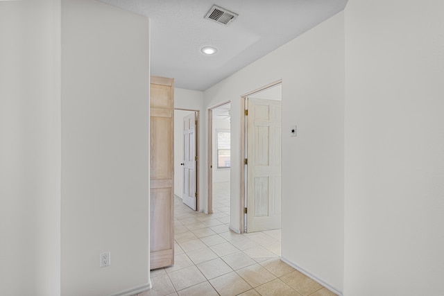 hall featuring light tile patterned flooring