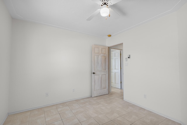 tiled empty room featuring ceiling fan