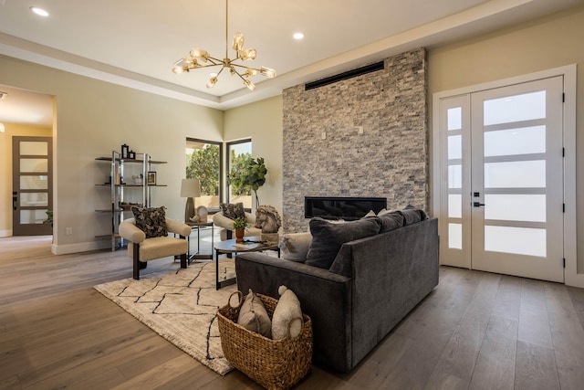 living room with hardwood / wood-style flooring, a fireplace, and a chandelier