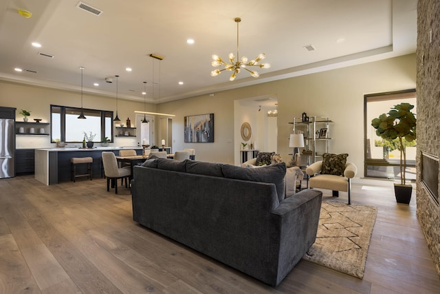 living room with wood-type flooring, a fireplace, and an inviting chandelier