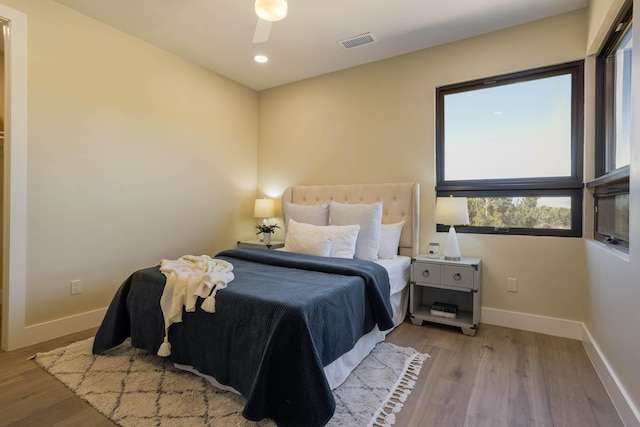 bedroom with light hardwood / wood-style floors and ceiling fan