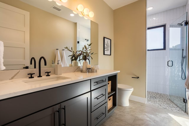 bathroom with vanity, a shower with shower door, toilet, and tile patterned floors