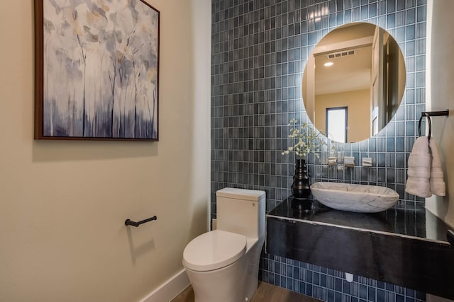 bathroom featuring tile walls, hardwood / wood-style floors, and toilet