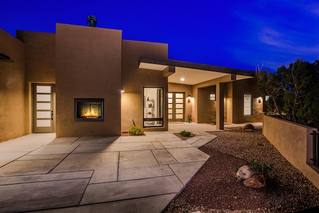 exterior entry at twilight featuring a patio