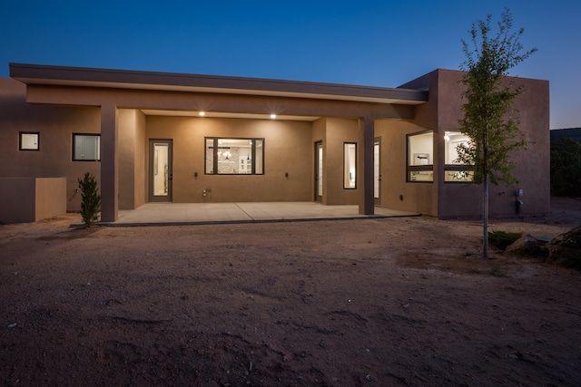 back house at dusk with a patio