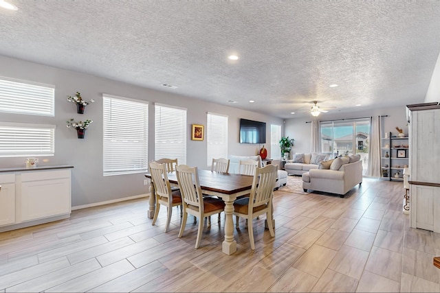 dining space featuring a textured ceiling, light hardwood / wood-style floors, and ceiling fan