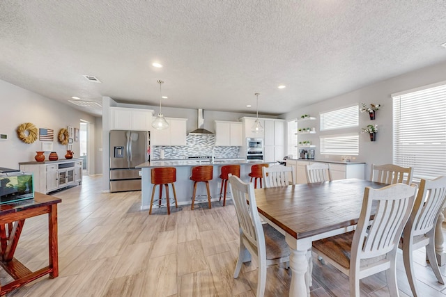 dining room with a textured ceiling and light wood-type flooring