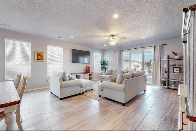 living room featuring a textured ceiling and ceiling fan