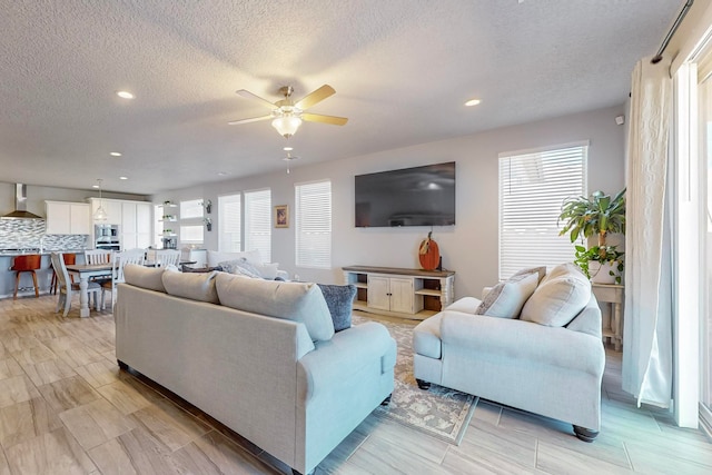 living room featuring a textured ceiling, plenty of natural light, and ceiling fan