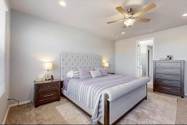 bedroom featuring ceiling fan, light carpet, and ensuite bathroom