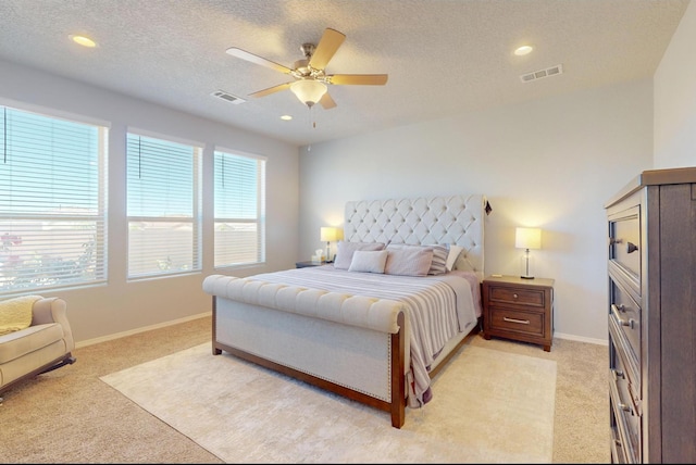 carpeted bedroom with a textured ceiling and ceiling fan