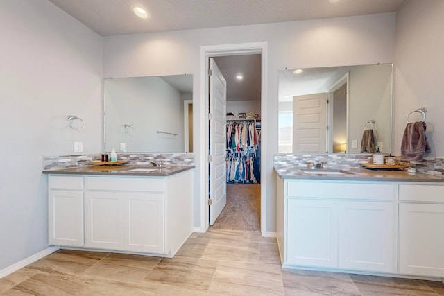 bathroom featuring vanity and backsplash