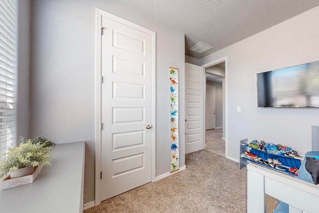 carpeted bedroom featuring multiple windows and a textured ceiling